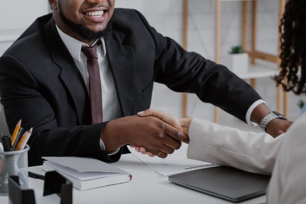 Interviewer and interviewee shaking hands during an interview.
