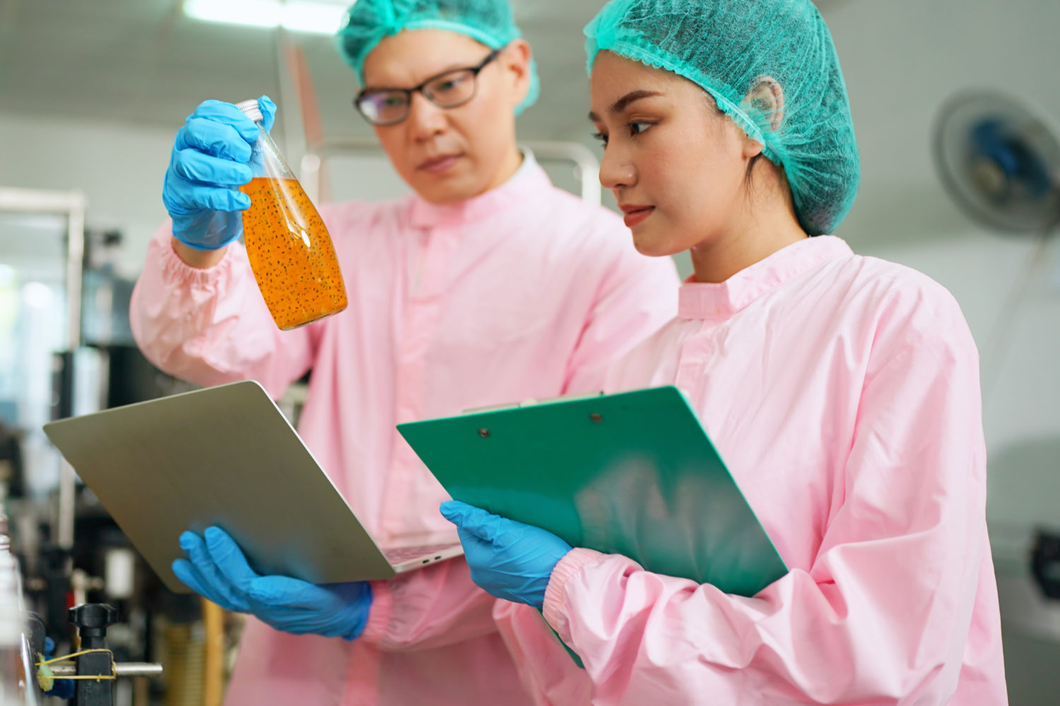 worker controlling the work of machine in production line at beverage industry.